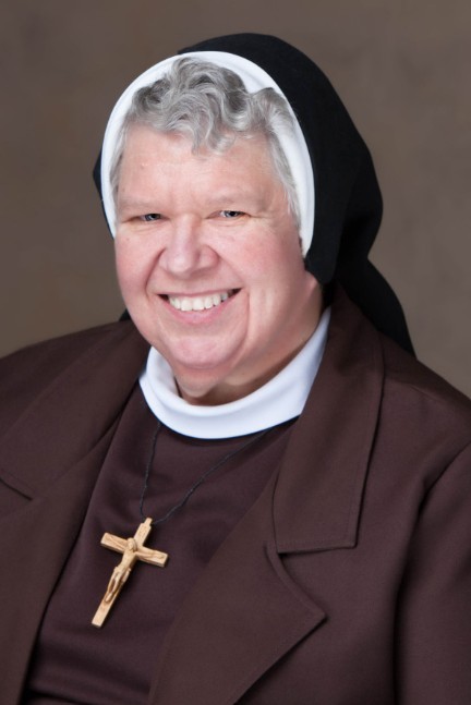 Headshot of a smiling woman in a habit.