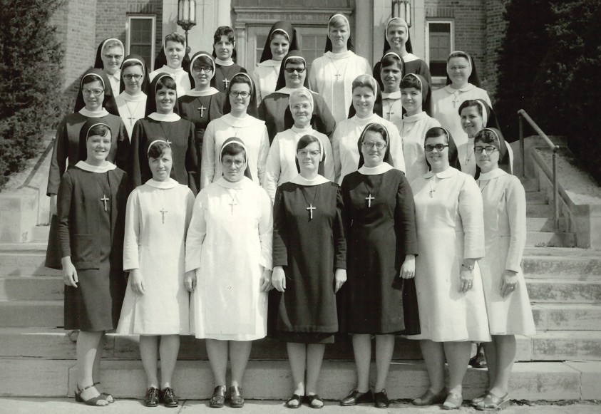 A group os sisters standing on the steps of a building.