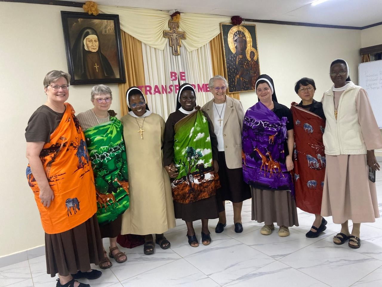 Eight sisters standing together in a room.